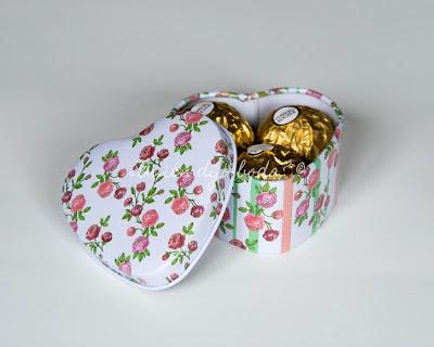 Caja metálica con estampado de flores conteniendo tres bombones