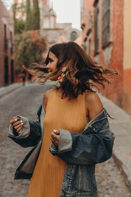 Sara of Collage Vintage wearing a long mustard dress and embroidered sneakers
