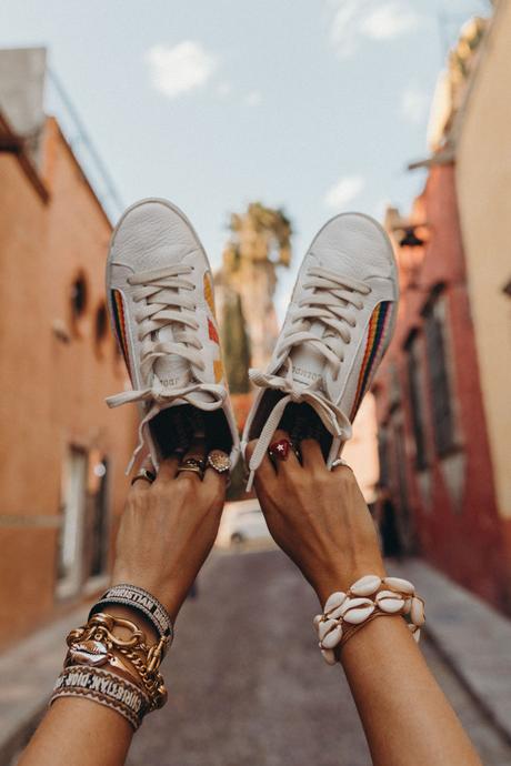 Sara of Collage Vintage wearing a long mustard dress and embroidered sneakers