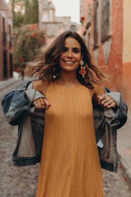 Sara of Collage Vintage wearing a long mustard dress and embroidered sneakers