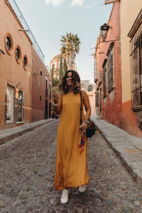 Sara of Collage Vintage wearing a long mustard dress and embroidered sneakers