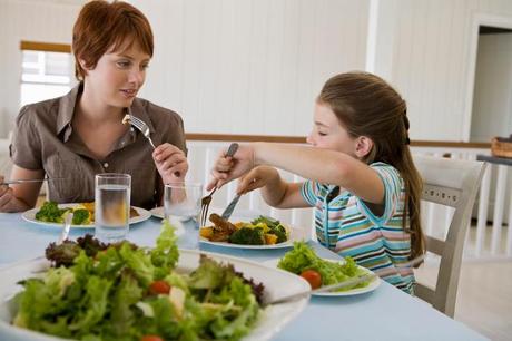 Niña y madre comiendo juntas Niña y madre comiendo juntas