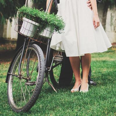 Novios con una bicicleta pisando el césped