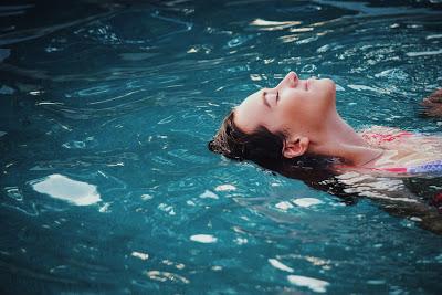 Chica bañándose en la piscina