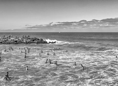 Gente en el agua esperando las olas del mar.