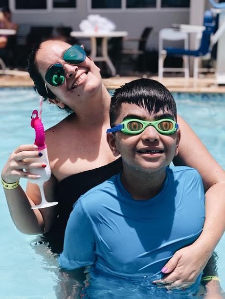 madre e hijo en una piscina tomando piña colada