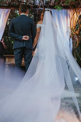 Novios tomados de la mano delante de la mesa de ceremonias