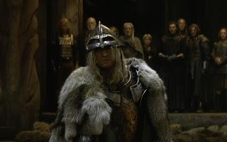 Fotograma de la película El guerrero nº 13, en el que se ve un vikingo rubio vistiendo pieles y portando un casco de metal, plateado.