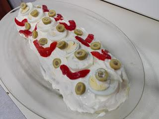 Rollo de patata relleno y adornado Rollo de patata relleno, cubierto de mayonesa y adornado en una fuente