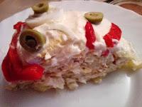 trozo de rollo de patata cubierto de mayonesa, aceitunas y tiras de pimiento asado