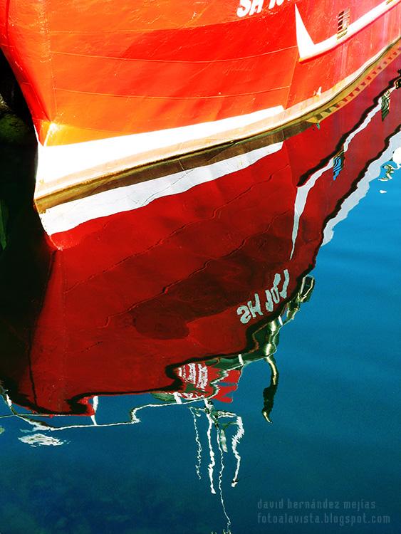 Reflejos en el agua de un barco amarrado en un puerto del mar de Islandia