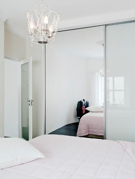 suelo de losas de piedra italiana sofá chaiselong salón y cocina en dos niveles piso sueco piso en dos niveles paredes redondeadas muebles de cocina bajos estilo nórdico estilo escandinavo escaleras de cristal diseño de interiores decoración sueca decoración de interiores cuadro con zapatos colcha rosa cocina moderna cocina blanca 