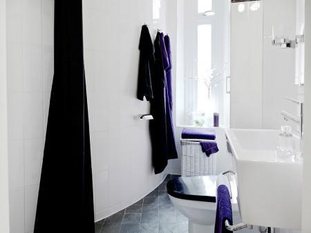 suelo de losas de piedra italiana sofá chaiselong salón y cocina en dos niveles piso sueco piso en dos niveles paredes redondeadas muebles de cocina bajos estilo nórdico estilo escandinavo escaleras de cristal diseño de interiores decoración sueca decoración de interiores cuadro con zapatos colcha rosa cocina moderna cocina blanca 