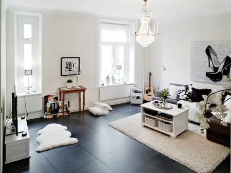 suelo de losas de piedra italiana sofá chaiselong salón y cocina en dos niveles piso sueco piso en dos niveles paredes redondeadas muebles de cocina bajos estilo nórdico estilo escandinavo escaleras de cristal diseño de interiores decoración sueca decoración de interiores cuadro con zapatos colcha rosa cocina moderna cocina blanca 