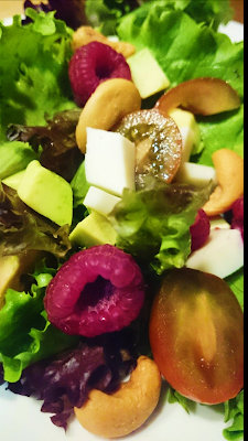 Ensalada de queso de cabra Malagueña y frambuesas con anacardos.