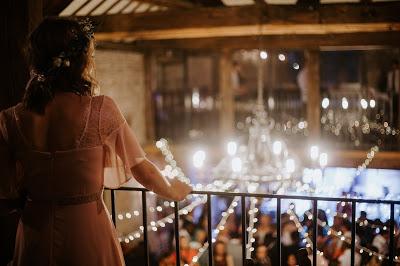 Novia mirando a los invitados desde una barandilla