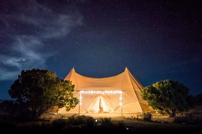 Carpa para boda instalada en espacio natural y con iluminación en el acceso