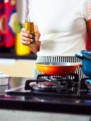 Mujer cocinando con aceite de oliva