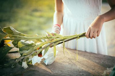 Mujer manipulando un ramo de flores sobre una mesa