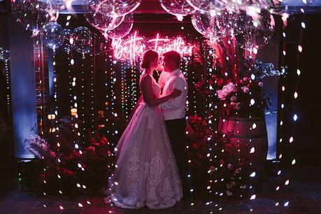 Boda interior con mucho rollo | Novios luces de neon globos contraluz | www.bodasdecuento.com