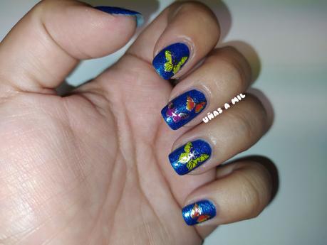 Diseño de uñas en azul con mariposas