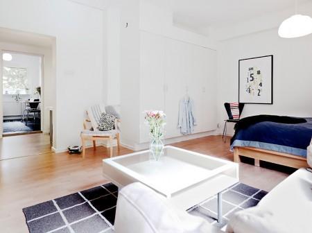 suelo de tarima suelo de gress negro sofa blanco separación de salón y cama separación de ambientes mini pisos mampara en el salón lámpara de diseño diseño de interires decoración espacios pequeños decoración de interiores decoración de estudios pequeños cocinas blancas 