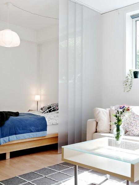 suelo de tarima suelo de gress negro sofa blanco separación de salón y cama separación de ambientes mini pisos mampara en el salón lámpara de diseño diseño de interires decoración espacios pequeños decoración de interiores decoración de estudios pequeños cocinas blancas 