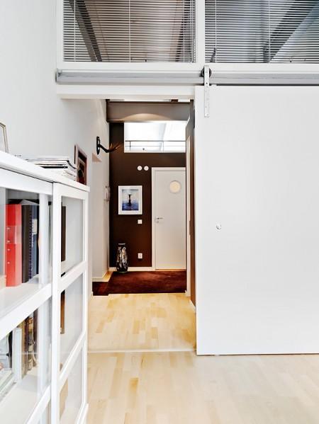 Aires de loft en un sexto piso vigas de metal piso nórdico muebles de balcón loft lámparas de estilo industrial grandes ventanales diseño de interiores decoración sueca decoración nórdica cocinas modernas cocinas blancas barra en la cocina