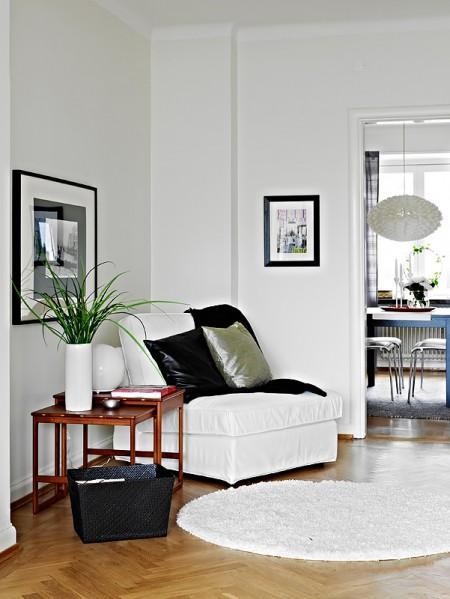 suelo de parquet sofa gris oscuro muebles de ikea lámpara negra grandes ventanales estilo nórdico estilo escandinavo diseño de interiores decoración en gris y negro decoración en blanco decoración de interiores cocinas blancas 