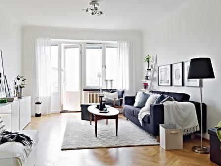 suelo de parquet sofa gris oscuro muebles de ikea lámpara negra grandes ventanales estilo nórdico estilo escandinavo diseño de interiores decoración en gris y negro decoración en blanco decoración de interiores cocinas blancas 