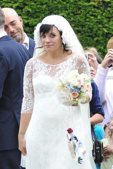 Lily Allen THE HAPPY COUPLE! Lily Allen and Sam Cooper emerge from St James The Great Church in Cranham after their wedding. Lily was wearing a Chanel lace dress created by Karl Lagerfeld and was looking estatically happy following her marriage to Sam.  The singer-turned-businesswoman was carrying a bouquet with a knitted bride and groom hanging from the stems.