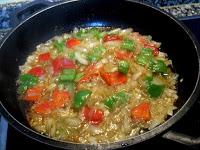 Pochando cebolla y pimientos Pochando cebolla y pimientos verde y rojo picados.