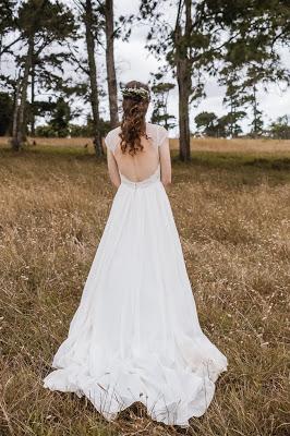 Novia vestida de blanco en un paisaje campestre