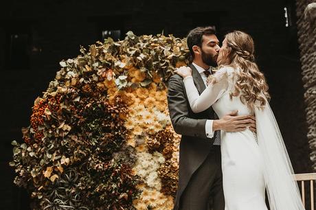 Ceremonia de boda de invierno con backdrop circular de flores novios beso