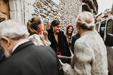 invitados con abrigos a la entrada de una boda de invierno en el pirineo