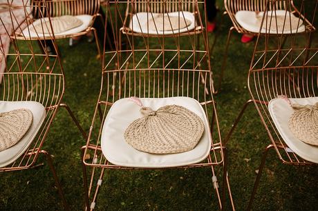 Dos novias y un boda boho chic sillas de color cobre con almohada blanca y abanico paipai de mimbre | boda boho chic Bodas de cuento