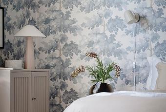 Delicado dormitorio con papel de pared pintado en florales y ambiente