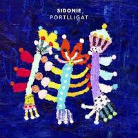 ortlligat es la segunda entrega musical de “El Regreso de Abba”, la nueva aventura de Sidonie que transcurre por las páginas de la primera novela de Marc Ros y por los surcos de un doble álbum que verá la luz este próximo otoño. Será la primera canción cantada en catalán que aparezca en un disco de la banda. Si en el primer single adelanto, “Me Llamo Abba”, Marc se ponía en la piel de la protagonista femenina de la historia, ahora le toca entrar en la mente lisérgica de Domènech: un psiconauta entrañable, fan del Rock ácido de California y tan cinéfilo que ha sido herido de bala por el ojo-revólver de Jean-Luc Godard. Él es el responsable de documentar en imágenes los acuerdos y desacuerdos de Abba y Hugo, estos dos músicos que se buscan huyendo y se encuentran perdiéndose. El reto de Jes, de Axel y de Marc ha sido intentar traducir en sonidos lo que la cámara de Domènech ve en este escenario-personaje que es Portlligat, situado al norte del municipio de Cadaqués: