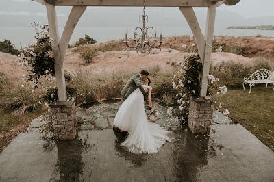 Pareja de novios besándose bajo el arco de la ceremonia de boda Pareja de novios besándose bajo el arco de la ceremonia de boda