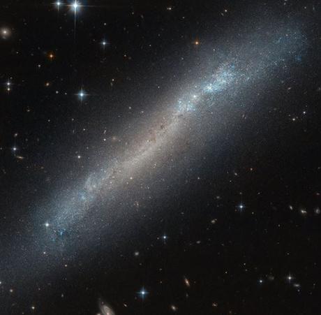 Las preciosas estrellas azules y naranjas de una tenue galaxia