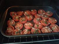 Colocando los tomate en el horno para asar.