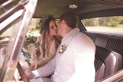 Pareja de novios besándose en el coche