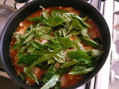 Pescado en salsa de jitomate con plátano macho, granos de elote, aceitunas y albahaca