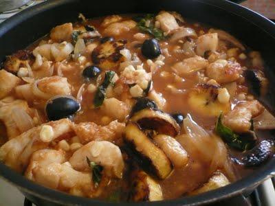 Pescado en salsa de jitomate con plátano macho, granos de elote, aceitunas y albahaca