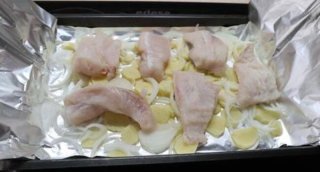 Ponemos los filetes de merluza encima de las patatas y la cebolla y le echamos un poco de sal