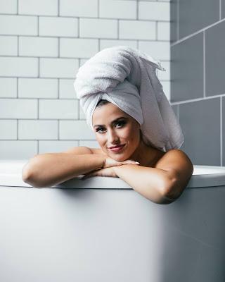 Mujer en el baño con una toalla a modo de turbante