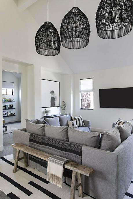 wicker patio furniture surf-inspired décor sliding glass doors outdoor fireplace open floor plan Newport Beach moody color scheme interiores abiertos interactive rooms industrial details gray sectional sofa estilo californiano decoración moderna decoración americana coastal décor charcoal gray decor california brass accessories backyard decor  