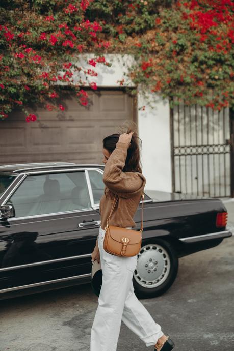 Sara from Collage Vintage wearing a camel Isabel Marant cashmere pullover and white Agolde jeans