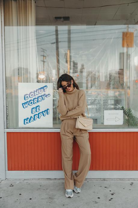 Donut worry be happy! Sara from Collage Vintage wearing a camel pullover and pleated high waist trousers from Closed