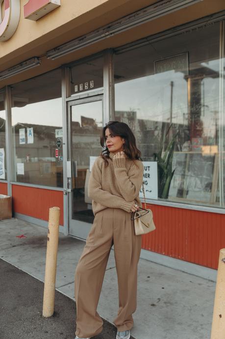 Donut worry be happy! Sara from Collage Vintage wearing a camel pullover and pleated high waist trousers from Closed